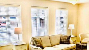 A living room with a beige sofa, two side tables with lamps, and a carpeted floor. - 3-bed House in Armagh City (Armagh)