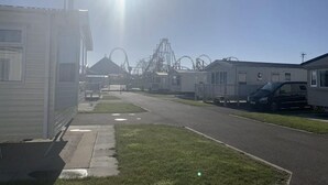 Eine Reihe von Mobilheimen mit einem Freizeitpark im Hintergrund.