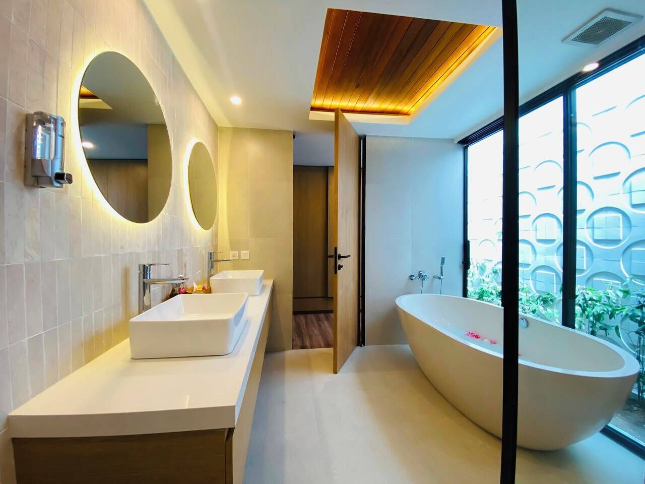 A modern bathroom with a freestanding bathtub, a vanity with a mirror, and a shower area.