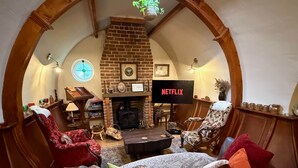 Una sala de estar acogedora con chimenea, televisor y asientos cómodos.