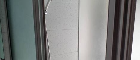 A modern bathroom with a shower, a sink, and a mirror.