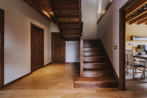 A wooden staircase leading to a dining area with chairs and a table. - 4 bedroom accommodation in Norte (Villadiego)