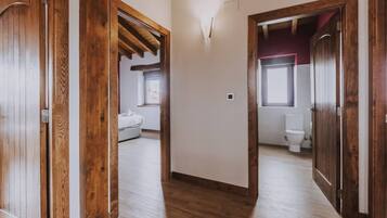 Un pasillo con puertas de madera que dan a un dormitorio y un baño.