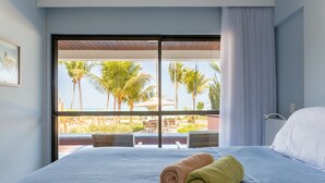 Une chambre d’hôtel avec une grande fenêtre, un lit et deux serviettes enroulées.