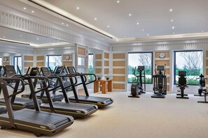 A gym with treadmills, exercise bikes, and weight machines. - Maysan Doha Lxr Hotels & Resorts (Al Rayyan)