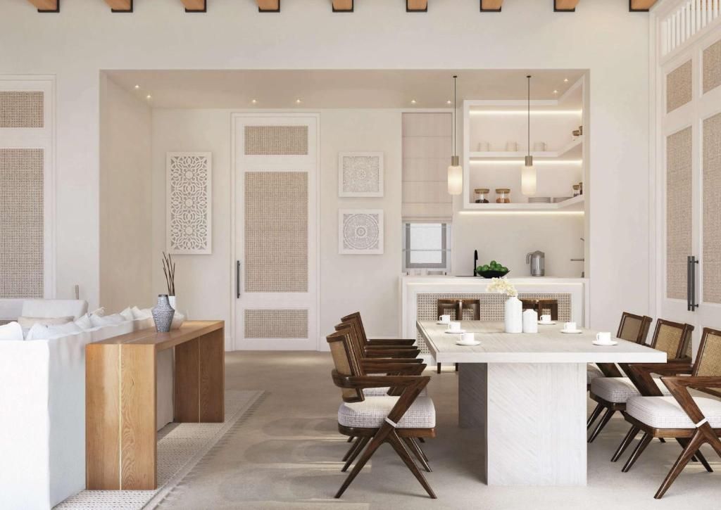 A modern kitchen with a central island, wooden chairs, and a dining table.