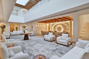 A spacious, well-lit interior with a high ceiling, multiple seating areas, and a central coffee table. - Maysan Doha Lxr Hotels & Resorts (Al Rayyan)