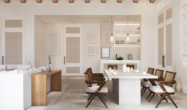 Un espace repas moderne avec un îlot central, des chaises en bois et une table blanche.