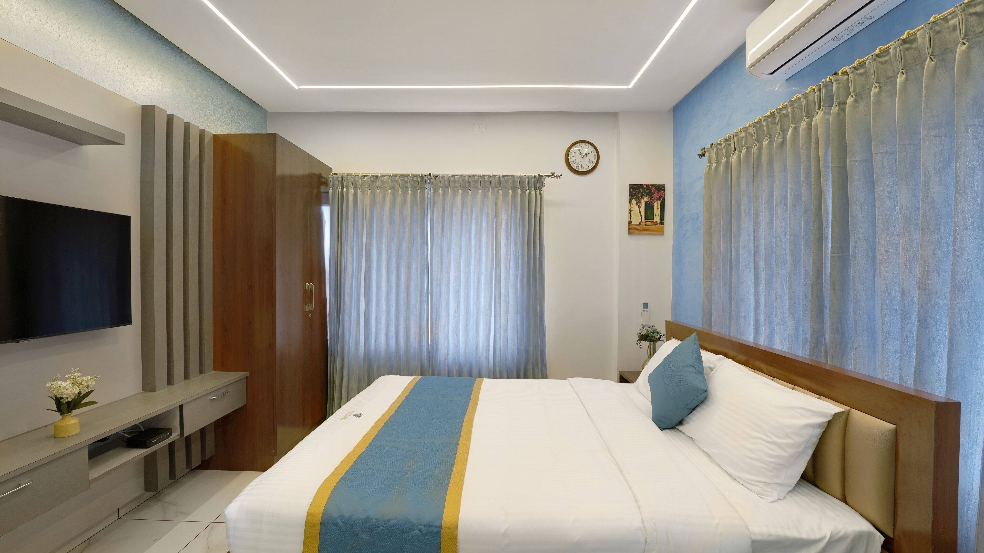 A hotel room with a bed, a TV, a desk, and a wardrobe.