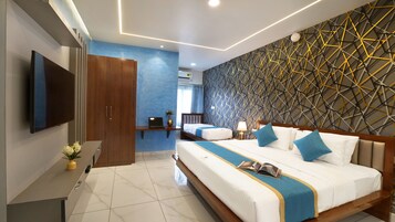 A modern hotel room with a large bed, a TV, a desk, and a decorative wall.