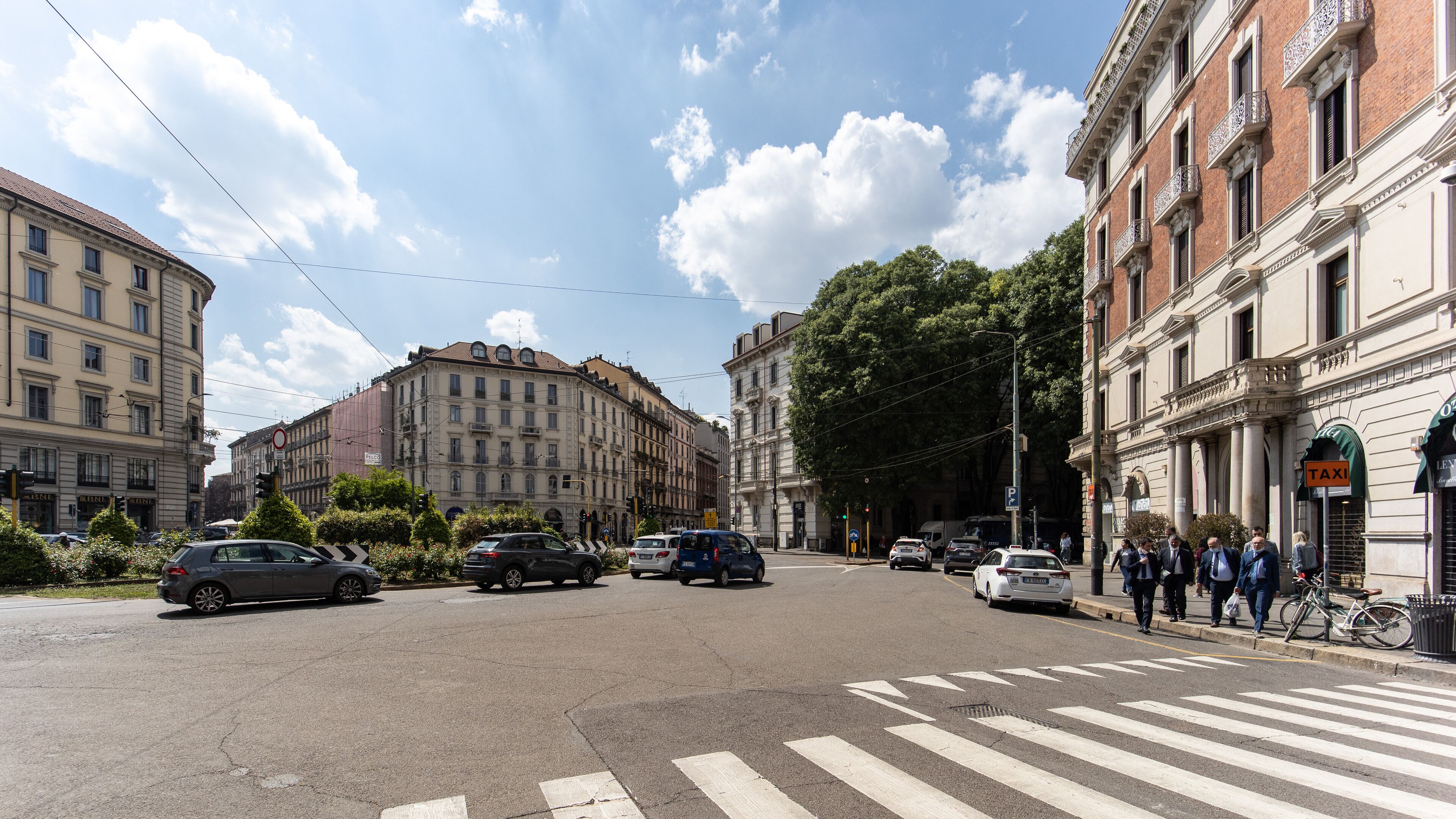 A street view with buildings, cars, and a crosswalk.