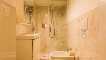 Une salle de bain moderne avec une douche à parois de verre, un lavabo et des toilettes.