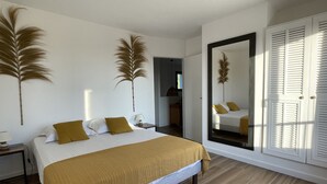 Un dormitorio con cama, mesita de noche, espejo y armario.