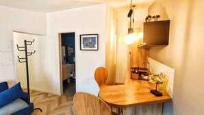 Espai vital reduït amb petita cuina, zona de dinar i zona de seure.