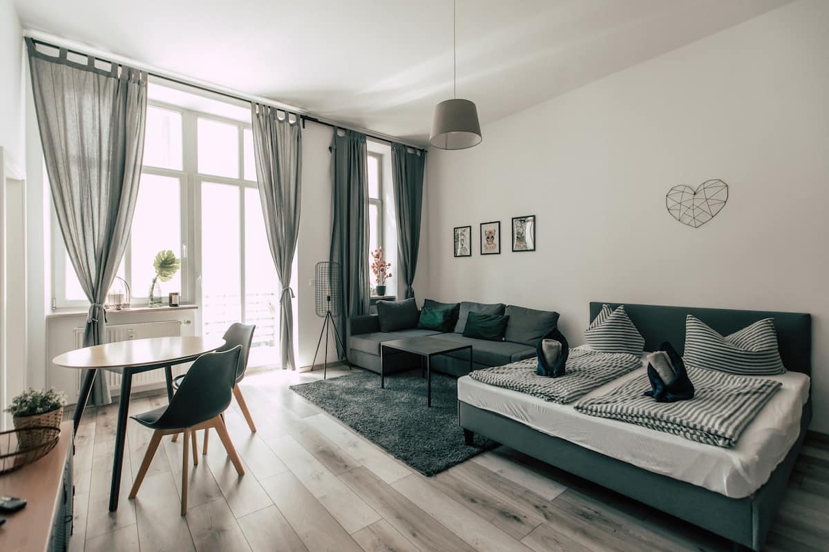 A modern living room with a sofa, coffee table, and dining area.
