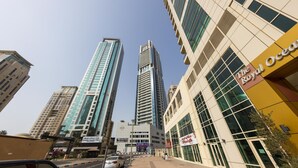 A cityscape with modern high-rise buildings, including a prominent hotel named "The Royal Ocean."