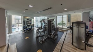 A gym with exercise equipment, large windows, and a Nautilus machine.