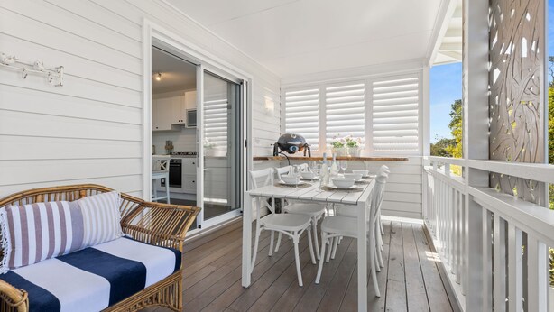 A covered outdoor area with a dining table set for four, a wicker sofa, and a grill. - By the Bay on Duncan by Experience Jervis Bay (Vincentia)