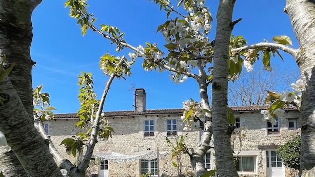 Un edificio de piedra con jardín y césped delantero.
