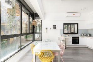 Eine moderne Küche mit weißer Arbeitsplatte, einem eingebauten Backofen und einem Fenster mit Blick auf die Stadt.