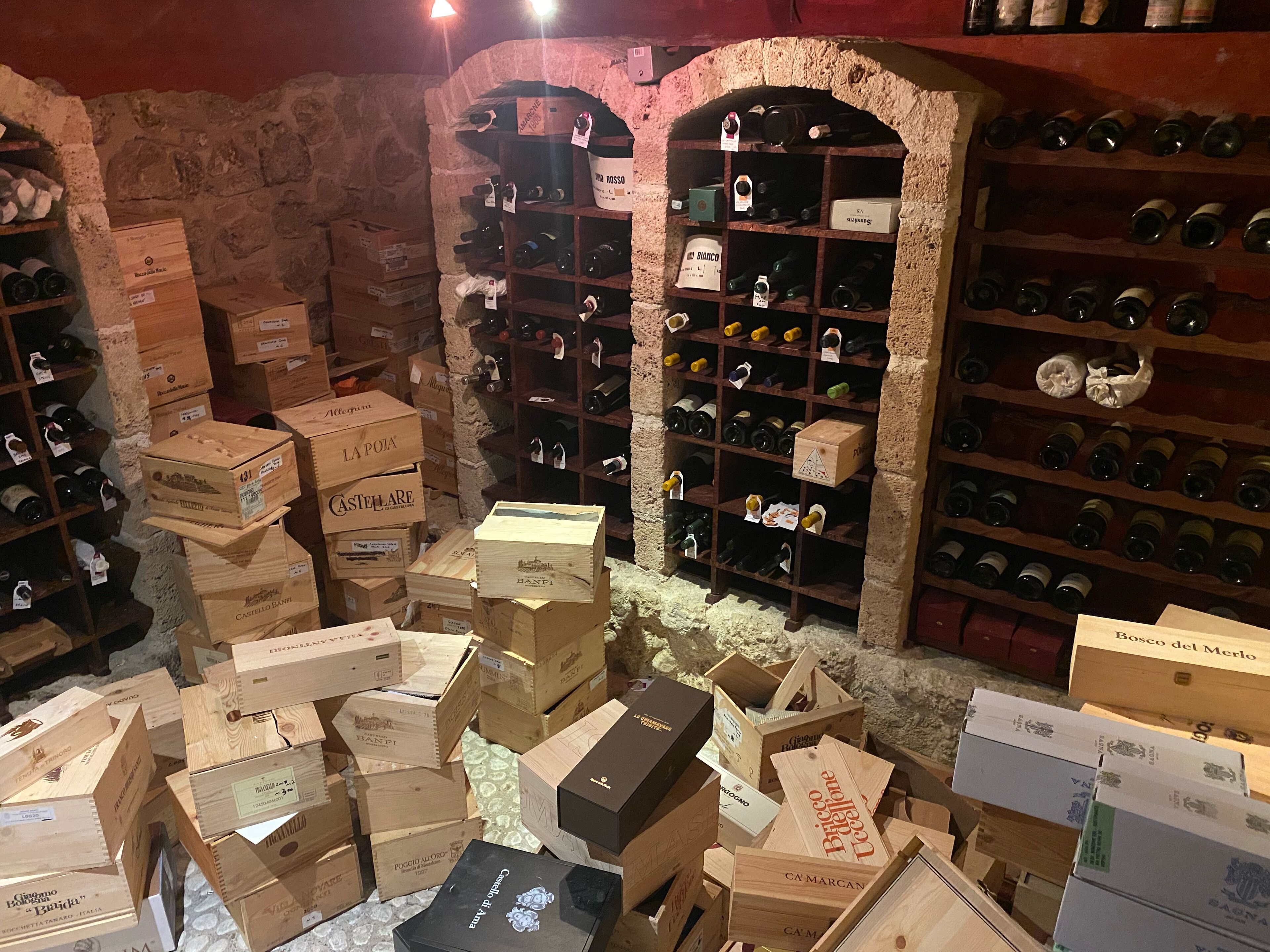 Ein Weinkeller mit Holzkisten und Regalen voller Weinflaschen.