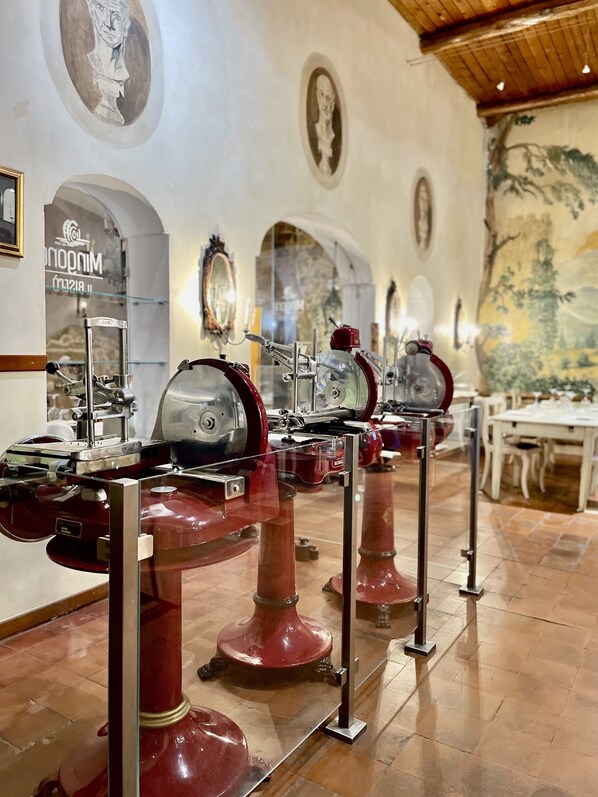 A restaurant with red tables and chairs, a tiled floor, and a mural on the wall.