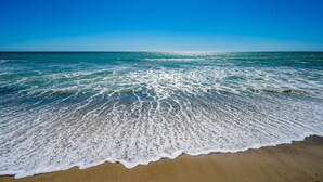 A beach with waves gently lapping onto the shore under a clear blue sky. - 35581 Beach Road: 4  BR, 4  BA House in Dana Point, Sleeps 8 (Dana Point)