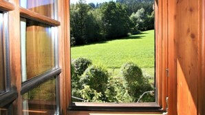 A wooden-framed window with a view of a green field and trees. - Vogelhütte by Interhome (Innsbruck)