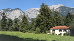A white building with a red roof, surrounded by green trees and mountains in the background. - Vogelhütte by Interhome (Innsbruck)