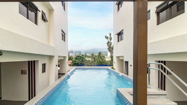 A swimming pool with a clear view of the surrounding buildings and distant landscape.
