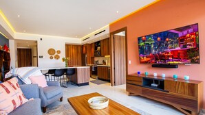 Ein modernes Wohnzimmer mit einer Couch, einem Couchtisch und einem an der Wand befestigten Fernseher.