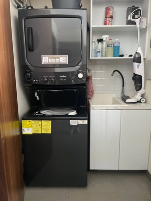 A kitchenette with a black mabe microwave, a built-in oven, and a sink. - Modern 2BR Near Beach & Boardwalk | Gym & BBQ (Puerto Vallarta)