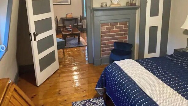 A bedroom with a bed, a fireplace, and a door leading to another room. - #4 Quaint 1 bedroom apartment in Historic Building (Newburgh)