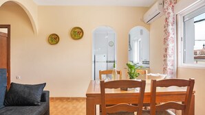 Ein Essbereich mit Holztisch, Stühlen und einer Couch.