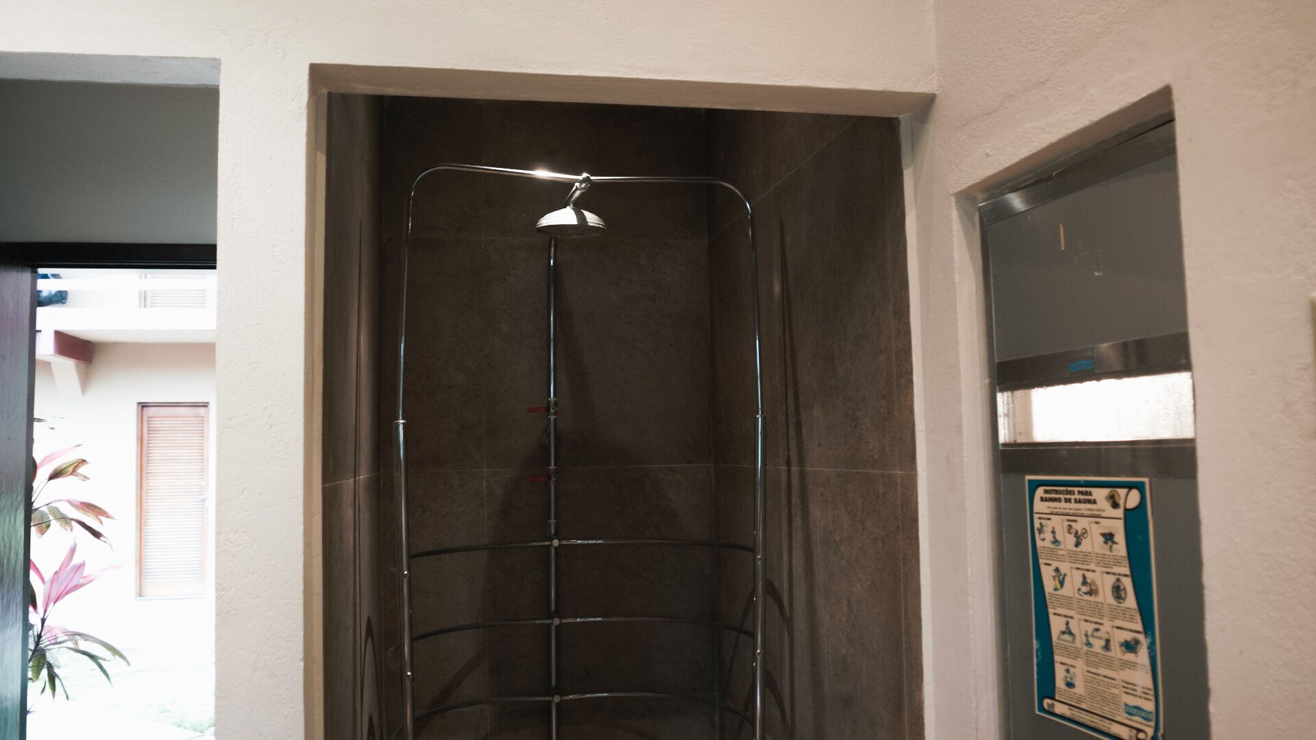 A shower with a glass door and a poster on the wall.