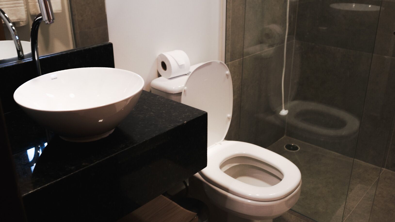 A bathroom with a white sink, toilet, and shower.