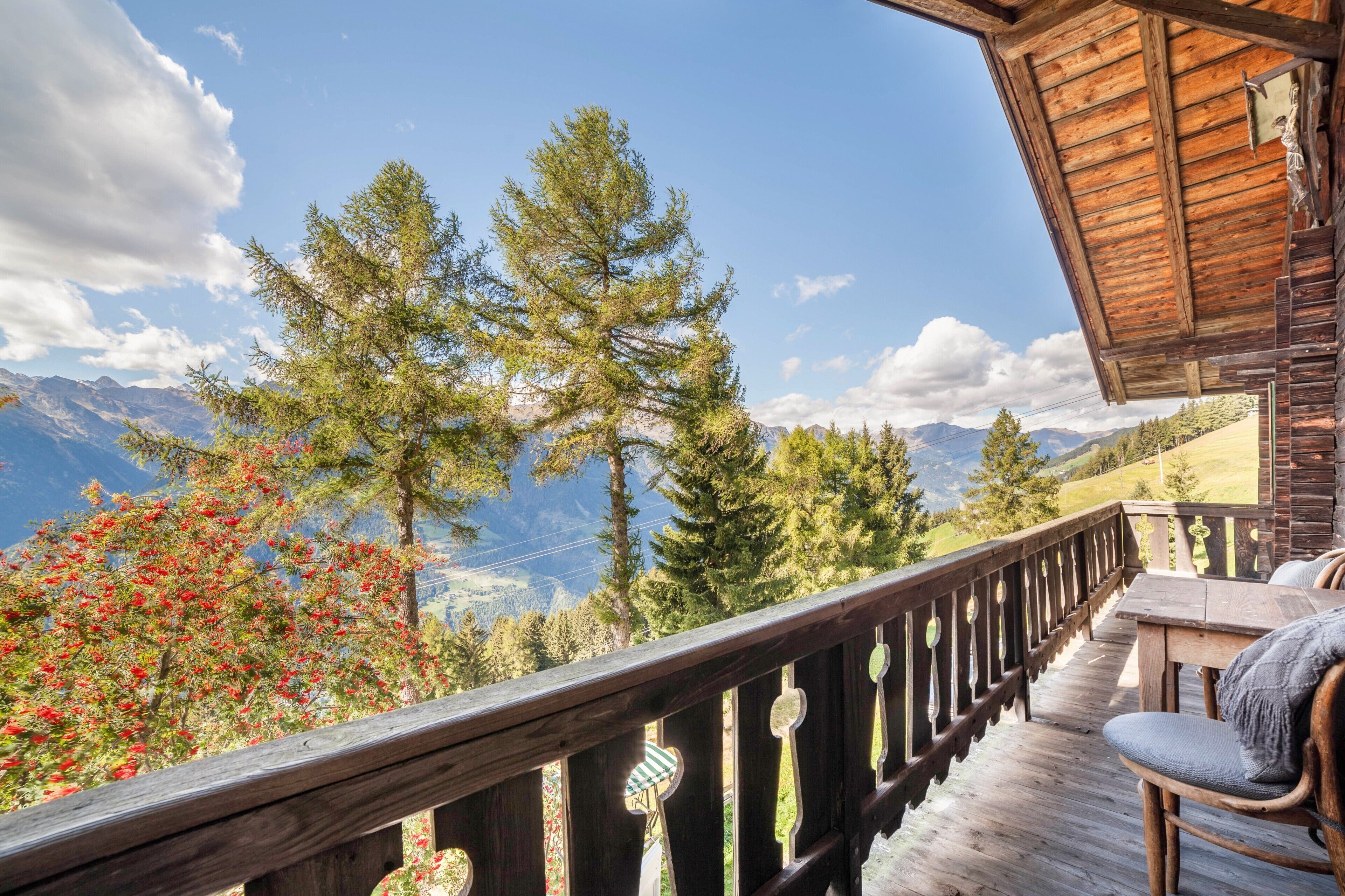 Ein hölzerner Balkon mit Blick auf Berge und Bäume.