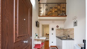 A compact kitchen with a dining area, a small island with a sink, and a balcony with a wrought iron railing. - Holiday Home "Sg Standard" with Landmark View, Terrace & Wi-Fi (Massafra)