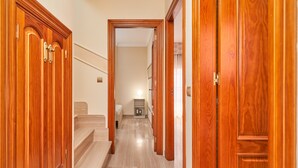 A hallway with wooden doors, a staircase, and a bed in the background. - Holiday Home Casa Murillo with Sea View, Terrace & Wi-Fi (Nerja)