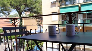 A balcony with two white mugs on a table, a chair, and a view of buildings and trees. - Italianway - Dogali 55 (Santa Margherita Ligure)