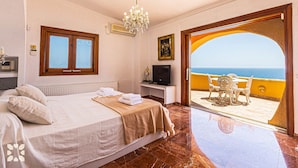 A bedroom with a bed, a TV, and a view of the sea. - Villa DIANA by Abahana Villas (Teulada)
