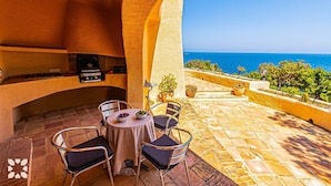 An outdoor patio with a grill, seating, and a view of the sea. - Villa DIANA by Abahana Villas (Teulada)
