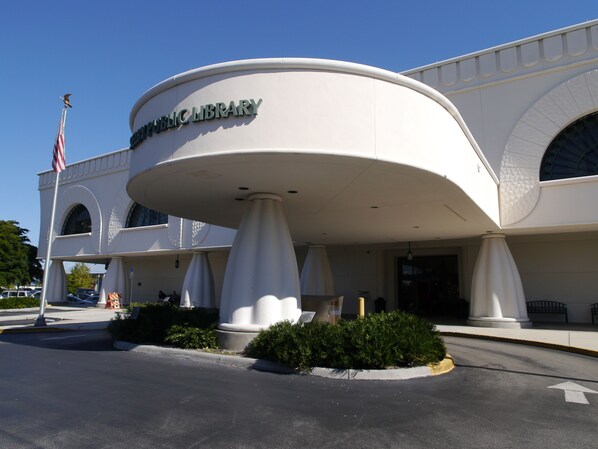 A public library with a distinctive rounded entrance and a flagpole with an American flag.