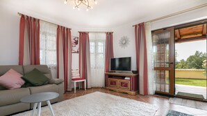 Un salon avec un canapé, un téléviseur et une vue sur l’extérieur.
