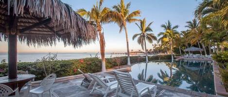 Piscina all'aperto, una piscina a sfioro, lettini