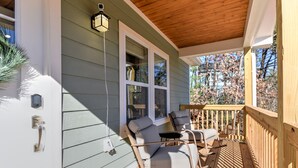 A wooden deck with rocking chairs and a covered area, connected to a house with green siding and white trim. - Cozy and Clean, Pet and Family-Friendly Gem; Minutes to Asheville (Weaverville)