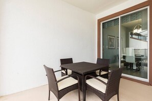 Un comedor con una mesa y cuatro sillas, un cerrojo corredizo y vistas del interior.