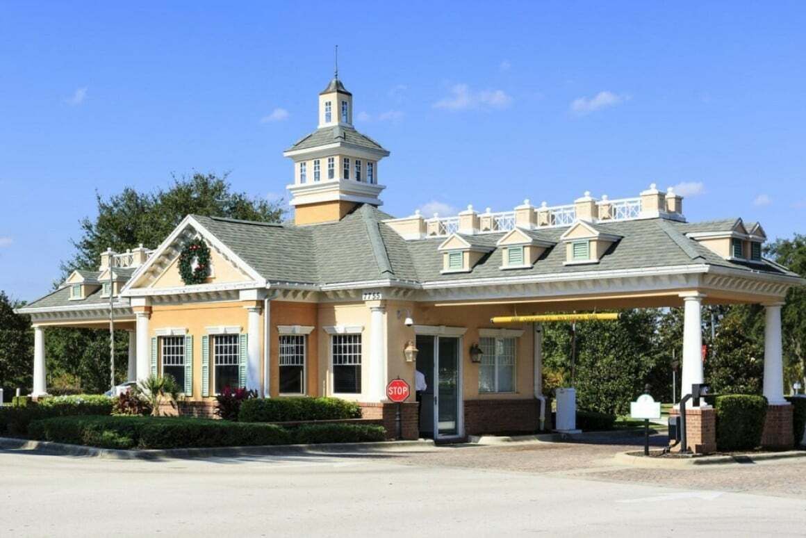 A hotel with a central tower, a covered entrance, and a stop sign.