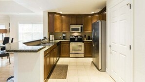 Une cuisine moderne avec des meubles en bois, des appareils en acier inoxydable et un îlot central.