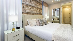Une chambre avec un mur d’accent en bois, une tête de lit capitonnée et une table de chevet avec une lampe.